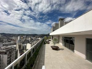 a balcony of a building with a view of a city at Studio Pink com ar, varanda, academia e piscina in Juiz de Fora