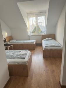 a room with three beds and a window at Hotel Daria in Wilków