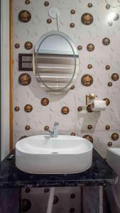 a bathroom with a sink and a mirror at 36 Yard Beach Cottages in Old Goa