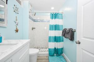 bagno con tenda doccia blu e bianca. di Park Place Unit 228 a Cedar Key