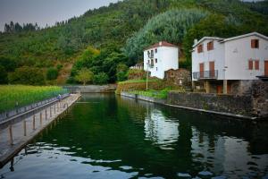 a river with buildings next to a mountain at Casa da Ti Cristina in Pomares