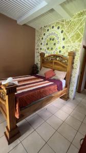 a bedroom with a wooden bed with a wall at 1961 Los Naranjos Hostal in Los Naranjos +5 photos