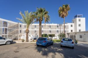 two cars parked in a parking lot in front of a building at TrendyHomes Neptuno Mojacar in Mojácar