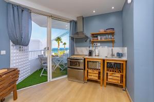 a kitchen with a stove and a balcony with the ocean at TrendyHomes Neptuno Mojacar in Mojácar