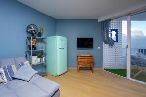 a living room with a couch and a refrigerator at TrendyHomes Neptuno Mojacar in Mojácar