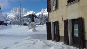 a building with a pile of snow in front of a mountain at Gite Seguret in Gresse-en-Vercors