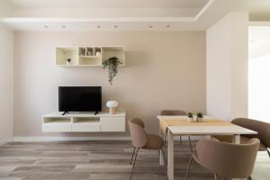 a living room with a tv and a table and chairs at Rhome to Colosseum in Rome
