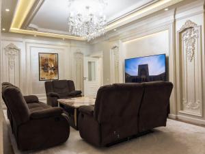 a dining room with chairs and a table and a chandelier at CityCenter Apartment in Samarkand