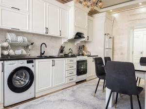 a kitchen with white cabinets and a washing machine at CityCenter Apartment in Samarkand
