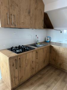 una cucina con mobili in legno e un forno a piano cottura di Mieszkanie Wieloosobowe a Wilków Altre 12 foto