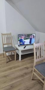 un soggiorno con una TV su un tavolo e una sedia di Mieszkanie Wieloosobowe a Wilków