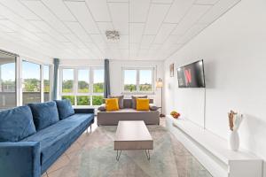 a living room with a blue couch and a table at Sunshine - 4 Personen Airport Messe mit TG-Garage in Ostfildern