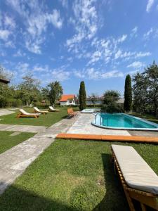 a swimming pool in a yard with benches at Casa Amalia Tocile -Sadu in Sadu