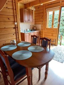 a dining room with a table and chairs in a cabin at Bieszczady Domek Letniskowy in Polańczyk +16 photos