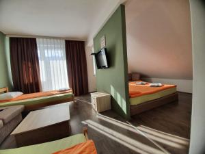 a hotel room with two beds and a tv at Hotel Arena - Teteks in Tetovo