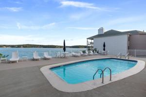 a swimming pool with chairs and a view of the water at Emerald Bay Overlook Breathtaking Views, Pools in Lake Ozark