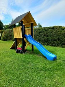 a playground with a slide and a gazebo at Bieszczady Domek Letniskowy in Polańczyk