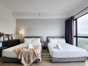 a bedroom with two beds with white sheets and a window at Mossaz at Empire Damansara by Wodages in Kuala Selangor