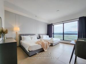 a hotel room with two beds and a large window at Mossaz at Empire Damansara by Wodages in Kuala Selangor