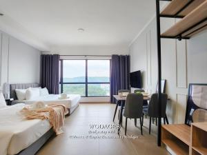 a hotel room with two beds and a table and a desk at Mossaz at Empire Damansara by Wodages in Kuala Selangor