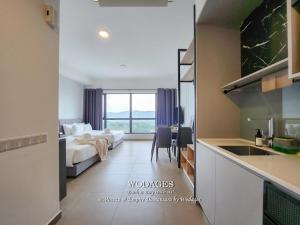 a hotel room with a bed and a kitchen with a sink at Mossaz at Empire Damansara by Wodages in Kuala Selangor