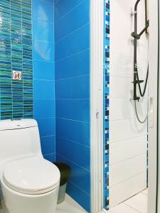 a blue bathroom with a toilet and a shower at 2BR Comfy Family Suite Hat Yai in Hat Yai