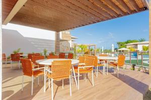 a patio with tables and chairs on a deck at GB110 Village Duplex 4 Suítes - Guarajuba in Monte Gordo