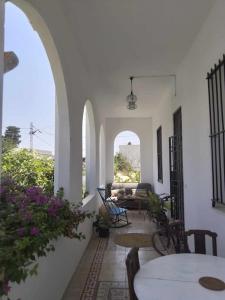 ein Wohnzimmer mit einem Tisch und Stühlen und einigen Blumen in der Unterkunft villa vincente in Salambôo