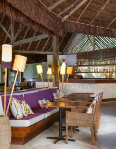 a restaurant with a purple couch and a table at Tivoli Ecoresort Praia do Forte in Praia do Forte