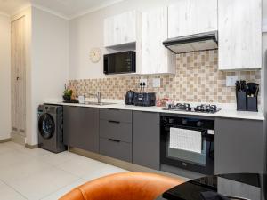 une cuisine avec un évier et une cuisinière dans l'établissement Anna Suite - Serenity & Stuff Luxury Apartments, à Midrand