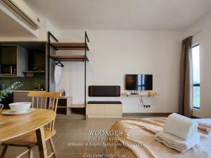 a bedroom with a bed and a table and a kitchen at Mossaz at Empire Damansara by Wodages in Kuala Selangor