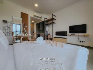 a large white bed in a room with a tv at Mossaz at Empire Damansara by Wodages in Kuala Selangor