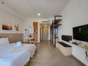a bedroom with a bed and a flat screen tv at Mossaz at Empire Damansara by Wodages in Kuala Selangor