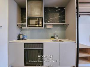 a kitchen with a microwave and a sink at Mossaz at Empire Damansara by Wodages in Kuala Selangor
