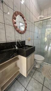 um banheiro com uma pia, um vaso sanitário e um espelho em Recanto do Martins em Florianópolis