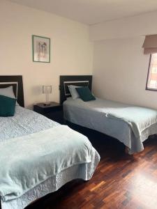 two beds in a room with wooden floors at Maywa at Central Miraflores in Lima
