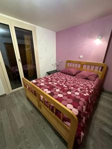 Un dormitorio con una cama de madera en una habitación. en À la Combote, en Vorges-les-Pins