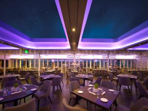 un restaurante con mesas, sillas e iluminación púrpura en Sunborn Gibraltar, en Gibraltar