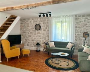 a living room with a couch and a tv at Casa Brullevi - villa u staroj jezgri s pogledom na more in Betina