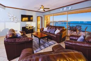 a living room with leather furniture and a view of the ocean at Spacious 4 bedroom Condo with expansive Ocean Views and luxurous features - #910 Sonoran Sky - RP Vacation in Puerto Peñasco