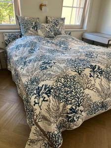 uma cama com um cobertor azul e branco e travesseiros em Daina Apartments Self check-in em Vilnius