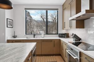 a kitchen with a sink and a large window at One Riverfront Townhome 05 by East West Hospitality in Avon