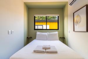 a bedroom with a bed with two towels on it at AC-BBQ-1000Mbps-Casa Container-Cozinha Completa in Florianópolis +37 photos