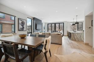 a dining room and living room with a table and chairs at One Riverfront Townhome 05 by East West Hospitality in Avon +57 photos