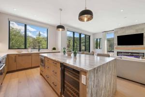 a large kitchen with a large island with a counter top at One Riverfront Townhome 07 by East West Hospitality in Avon