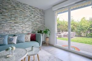 a living room with a couch and a large window at Le cocon bohème chic in Sartrouville