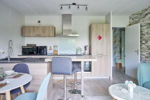 a kitchen and living room with a table and chairs at Le cocon bohème chic in Sartrouville