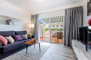 a living room with a couch and a tv at Amantes del Mar, Heated pool in Costa Del Silencio