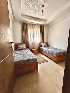 a bedroom with two beds and a window at Hammamet in Hammamet Sud