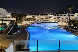 a swimming pool at night in a resort at Amantes del Mar, Heated pool in Costa Del Silencio